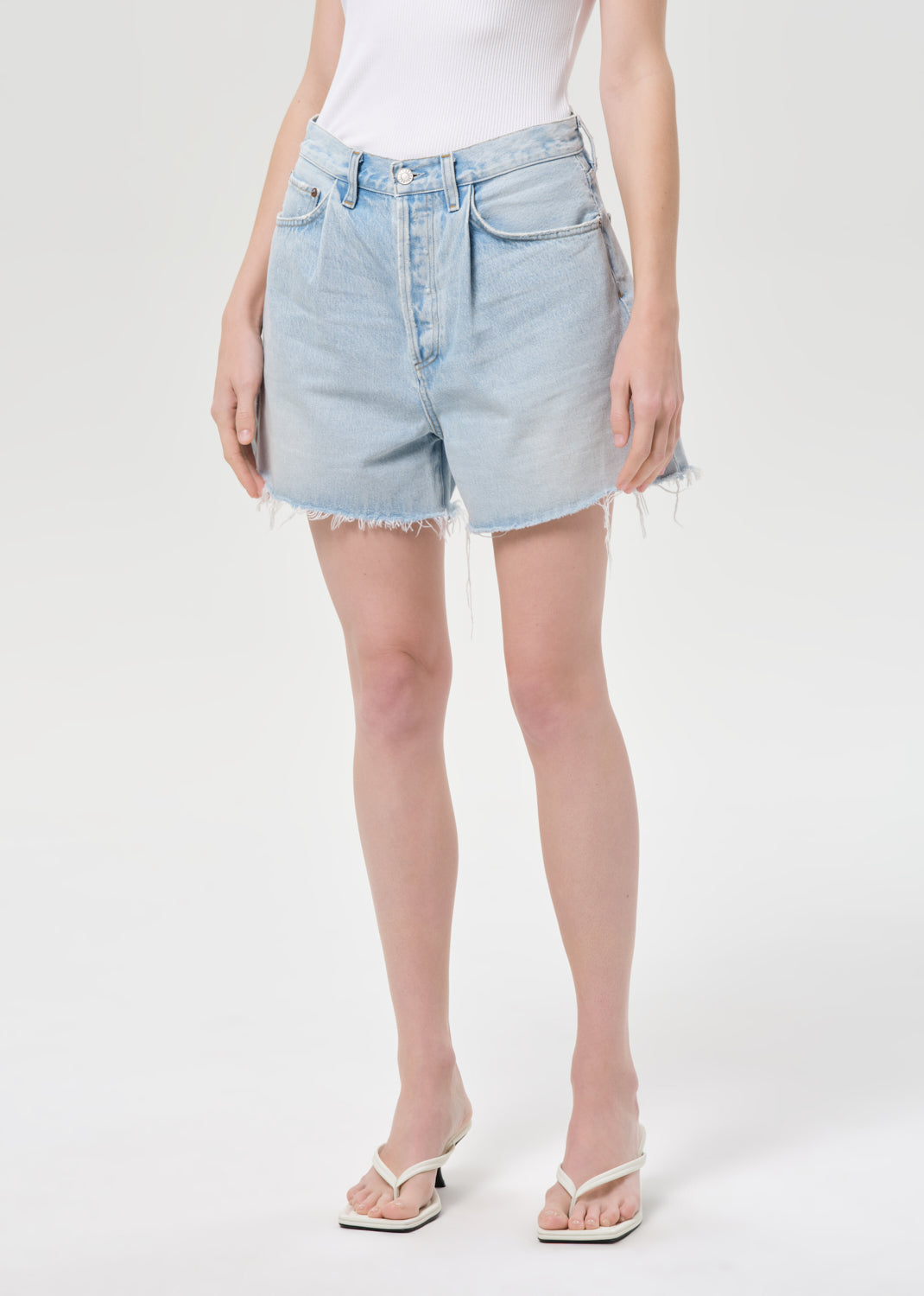 Person wearing light blue denim shorts on a white background