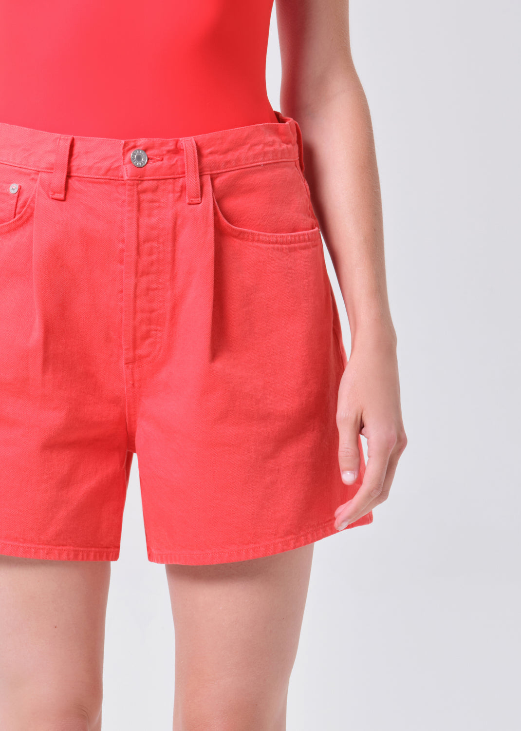 Red shorts worn by a person on a plain background