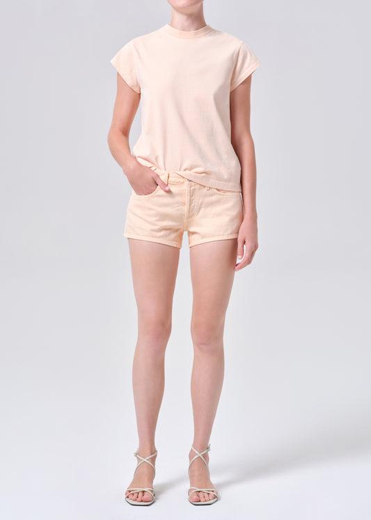 Person wearing a light pink t-shirt and shorts set on a white background