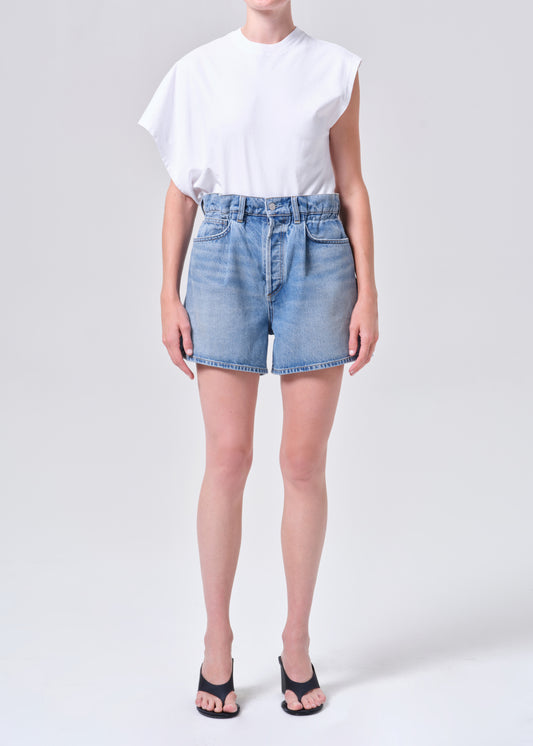 Person wearing a white t-shirt and light blue denim shorts on a plain background