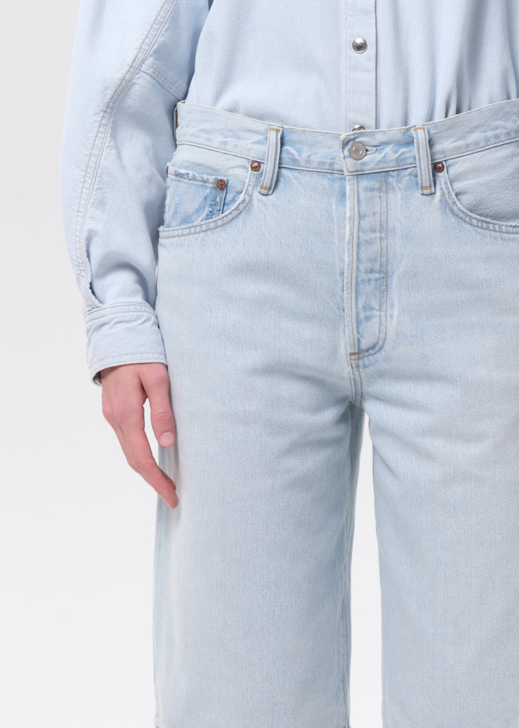 Light blue jeans worn by a person on a plain background