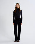 Woman wearing a black turtleneck and black pants on a white background