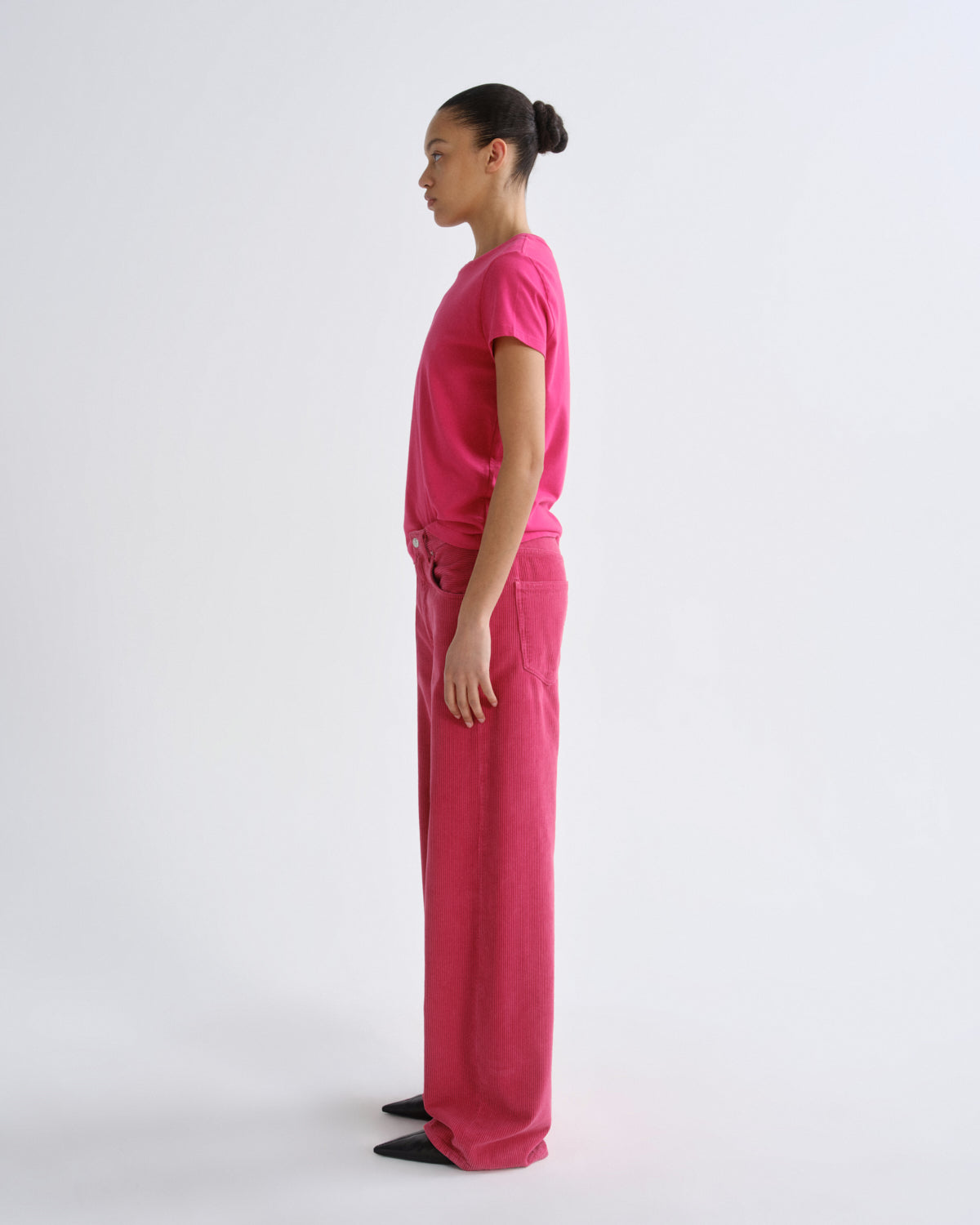 Person wearing a bright pink outfit on a white background