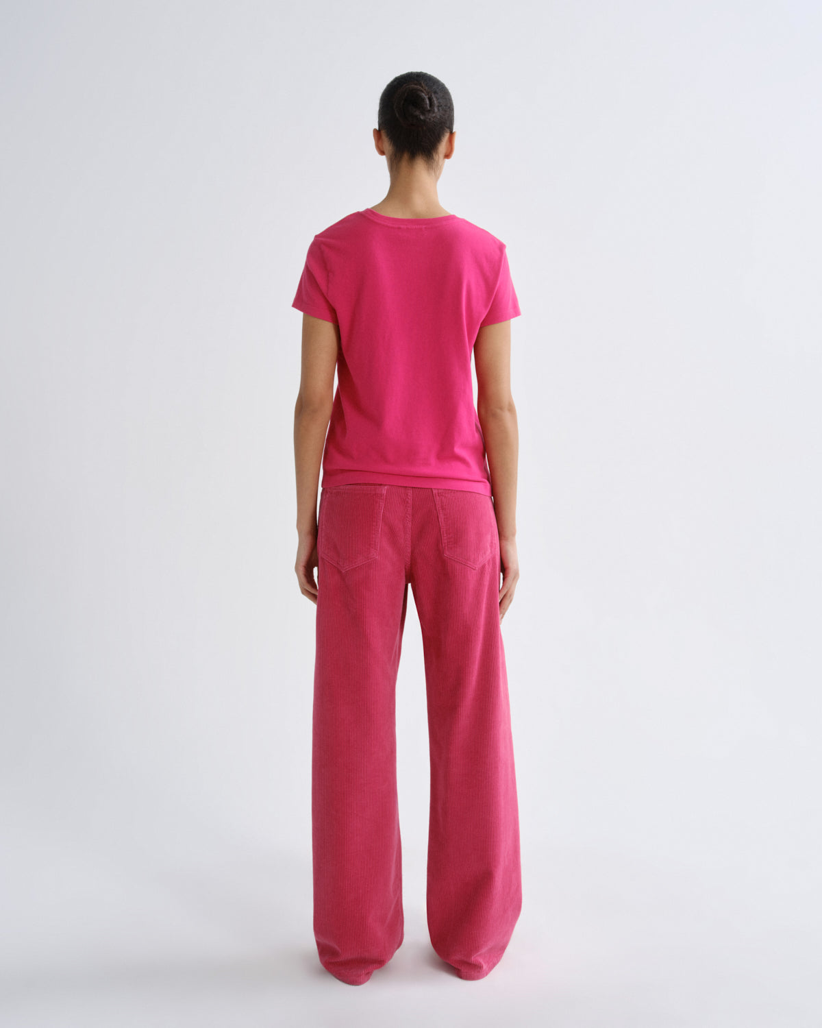 Person wearing a pink outfit on a white background