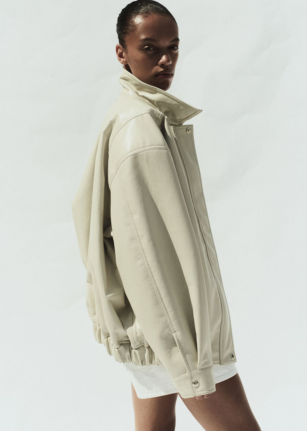 Woman wearing a beige jacket on a white background