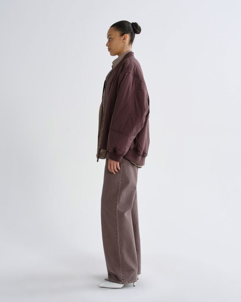 Person wearing a brown jacket and pants on a white background